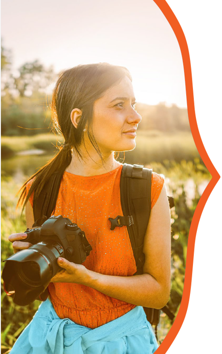 kvinna med kamera vid en äng